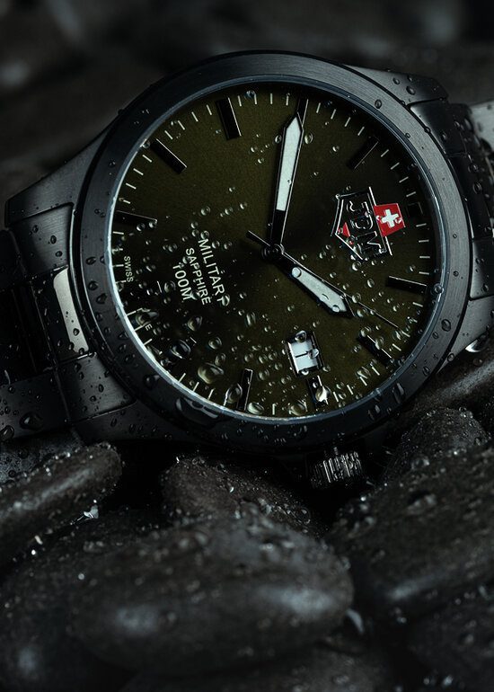 A wet JDM Military Sapphire men's watch sitting on pebbles, a photo by Seb Duper.