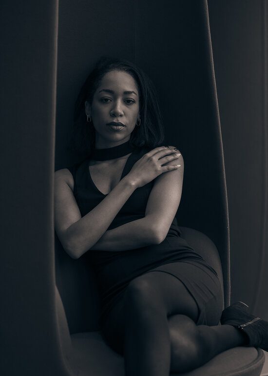 A black & white portrait of Ottawa model Jeminha Metellus on a chair, by Seb Duper