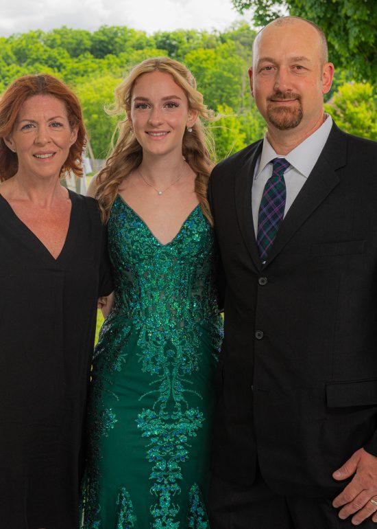 A high school graduate with her parents