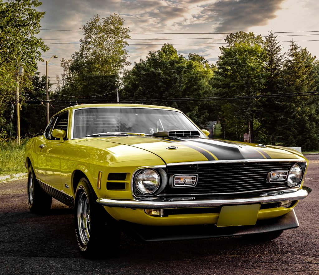A yellow and black 1971 Ford Mustang Mach 1 automobile.