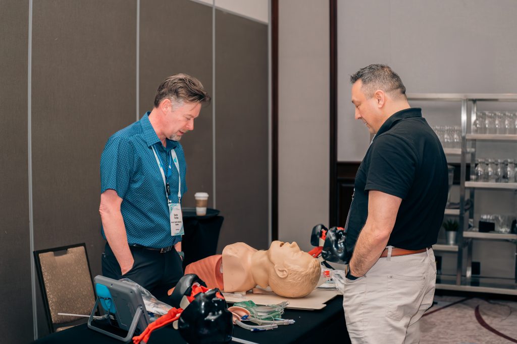 During a corporate event in Ottawa, a man provides a demonstration of medical equipment to another man.
